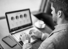 Black and white photo of hard working entrepreneur using laptop in coffee shop.